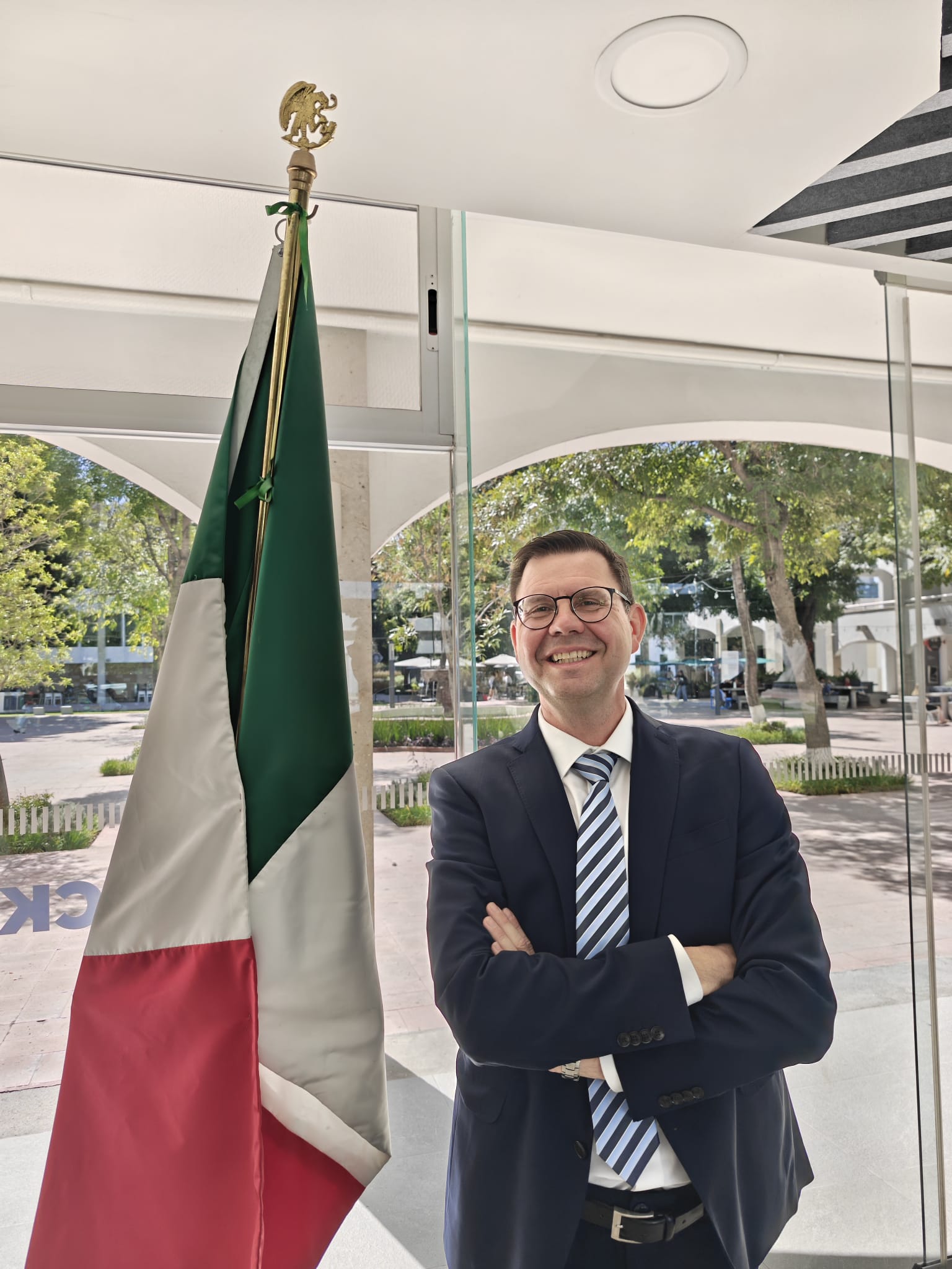 Prof. Dr. rer. pol. Rainer Geisler neben einer mexikanischen Flagge